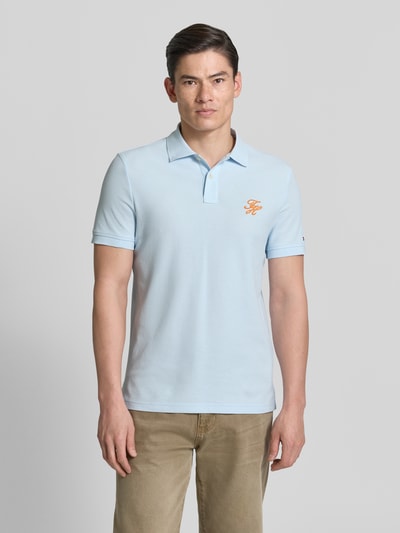 Männermodel trägt Regular Fit Poloshirt aus reiner Baumwolle von Tommy Hilfiger, Optik: Unifarben, Logo-Stitching, Ganzkörperansicht von vorne.