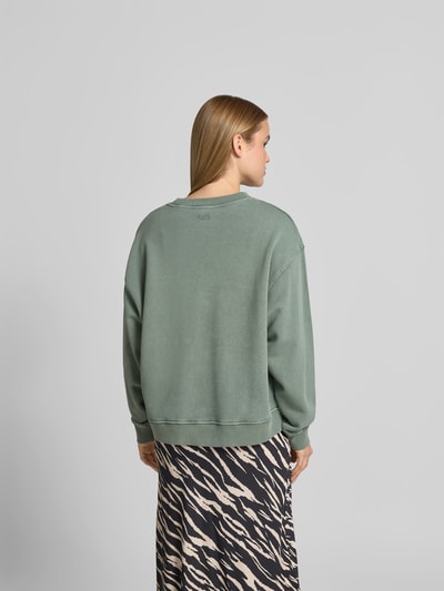 Frauenmodel trägt Oversized Sweatshirt mit Motiv-Print von Lala Berlin in Grün, reine Baumwolle, elastische Abschlüsse, Rückenansicht.