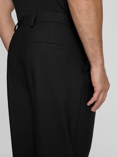 Männermodel trägt Straight Fit Hose aus Schurwoll-Mix Modell 'TONY' von HUGO, unifarben, Label Patch, Bundfalte, Nahaufnahme Rückansicht.