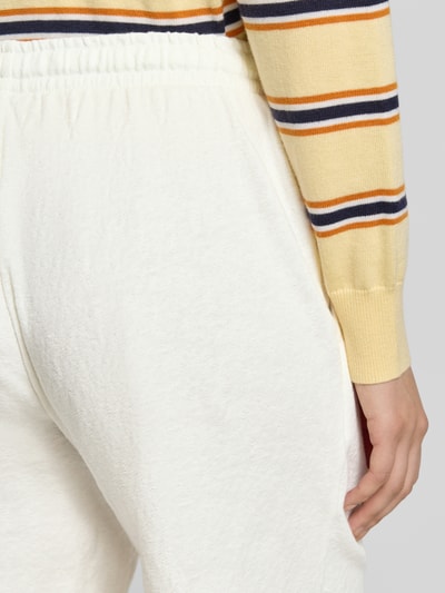 Vrouwenmodel draagt 'Shorts met zij-steekzakken' van Fynch-Hatton, witte kleur, loose fit, elastische band met trekkoord, labeldetail, detailopname heup.