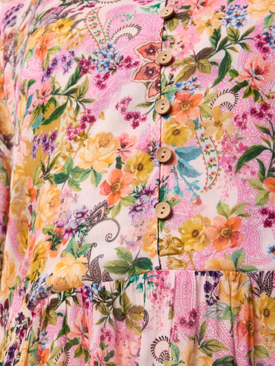 Frauenmodel trägt Knielanges Kleid aus reiner Viskose im Stufen-Look von WATERCULT mit floralem Print in Rosa, Gelb und Grün, Nahaufnahme Oberkörper. Lockere Passform, V-Ausschnitt mit Knopfleiste, Ballonärmeln mit elastischen Ärmelabschlüssen und Rüschenbesatz, elastischer Tailleneinsatz, Rückenlänge 92 cm, Brustweite 50 cm, Ärmellänge 70 cm.