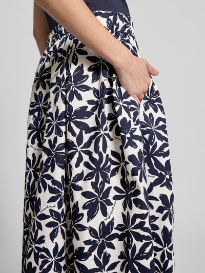Frauenmodel trägt Faltenrock im Allover-Look mit elastischem Bund von ROBE LÉGÈRE aus Baumwoll-Elasthan-Mix, Nahaufnahme Oberkörper.