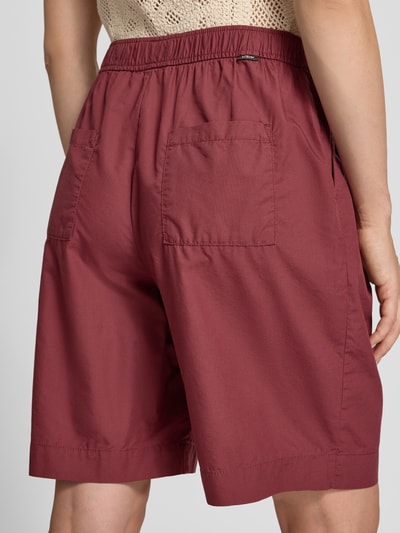 Kobiece modelka ma na sobie Relaxed Fit Bermuda aus reiner Baumwolle od s.Oliver RED LABEL, kolor bordowy, gładka faktura, widok całej sylwetki z tyłu