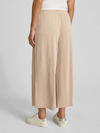 Vrouwenmodel draagt Straight Fit Stoffhose in verkürzter Passform van Christian Berg Woman, modalmix, elastische band met tunnelkoord, verkort, kleur beige, gladde textuur, dames stoffen broek, bandwijdte maat S 33 cm, binnenbeenlengte S 66 cm, Ganzkörperansicht Rückansicht.