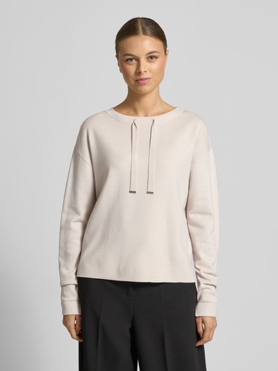 Frauenmodel trägt Strickpullover mit Tunnelzug von Betty Barclay in Beige, gerippte Abschlüsse, lockerer Schnitt, Ganzkörperansicht von vorne.