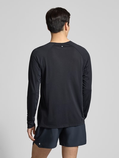 Männermodel trägt Funktionsshirt mit Logo und Rundhalsausschnitt von Salomon in Schwarz, glatte Struktur, Regular Fit, Rückansicht Ganzkörperansicht.