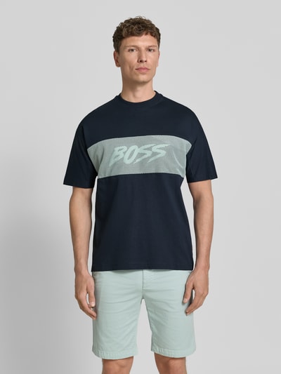 Männermodel trägt Regular Fit T-Shirt aus reiner Baumwolle Modell 'TE_BAYMESH' von BOSS Orange, unifarben, Mesh-Details, Label Print, Ganzkörperansicht von vorne.