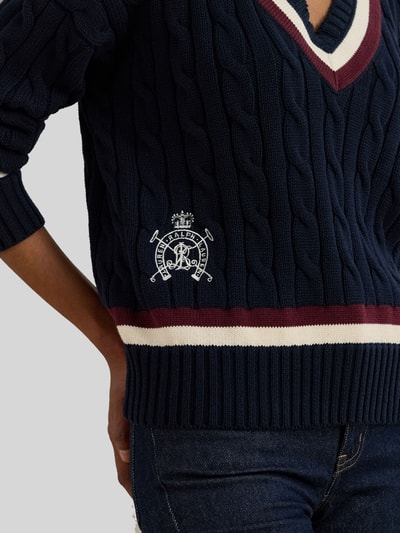 Frauenmodel trägt Regular Fit Strickpullover aus reiner Baumwolle von Lauren Ralph Lauren, Optik: Unifarben, Zopfmuster, Logo-Detail, Label-Stitching, Kontraststreifen, V-Ausschnitt, Langarm, gerippte Abschlüsse, Strick, Nahaufnahme Oberkörper.