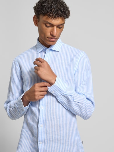 Männermodel trägt Modern Fit Freizeithemd aus Leinen mit Kentkragen von Matinique, hellblau-weiß gestreift, Knopfleiste, Nahaufnahme Oberkörper.