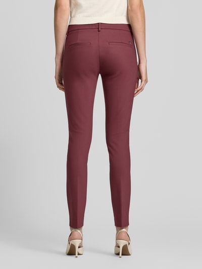 Vrouwenmodel draagt Slim Fit Anzughose aus Baumwoll-Mix van MOS MOSH in bordeauxrood, mix van katoen en elastaan, met riemlussen en gestileerde achterzakken, slim fit, knoop- en ritssluiting, Bandwijdte maat 36: 39 cm, Binnenbeenlengte maat 36: 76 cm, Ganzkörperansicht Rückansicht.