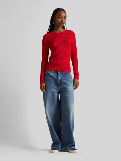 Frauenmodel trägt Strickpullover mit Zopfmuster Modell 'JULIANNA' von Polo Ralph Lauren in Rot, Baumwolle, Slim Fit, Ganzkörperansicht von vorne.