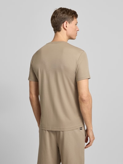 Männermodel trägt T-Shirt aus Viskose-Mix mit Label-Patch von EA7 Emporio Armani in Beige, Slim Fit, Rückenansicht, Ganzkörperansicht Rückansicht. Herren T-Shirt mit Stretch-Anteil, Rundhalsausschnitt, Rückenlänge bei Größe M 69 cm.