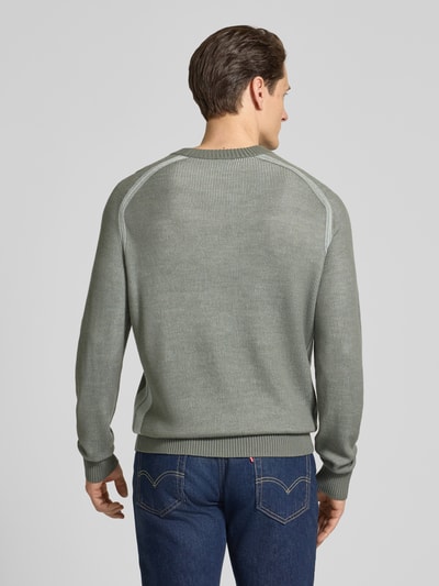 Mężczyzna model nosi Regular Fit Strickpullover aus Schurwoll-Mix Modell 'AKAJER' od BOSS Orange w odcieniu melanż szarym, detal strukturalny, raglanowy rękaw, mankiety oraz dół prążkowane, krój regular fit, widok całej sylwetki z tyłu.