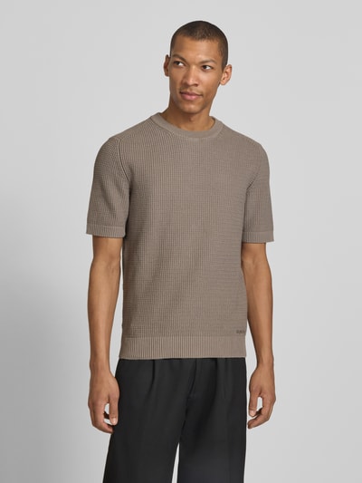 Männermodel trägt Relaxed Fit Strickpullover aus reiner Baumwolle Modell 'SAFFON' von HUGO in Beige, Waffelstrick, Nahaufnahme Oberkörper