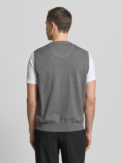 Männermodel trägt Pullunder mit Label-Stitching von Fynch-Hatton aus reiner Baumwolle, Regular-Fit, gerippte Abschlüsse, V-Ausschnitt, Rückenlänge 66 cm, Ganzkörperansicht Rückansicht.