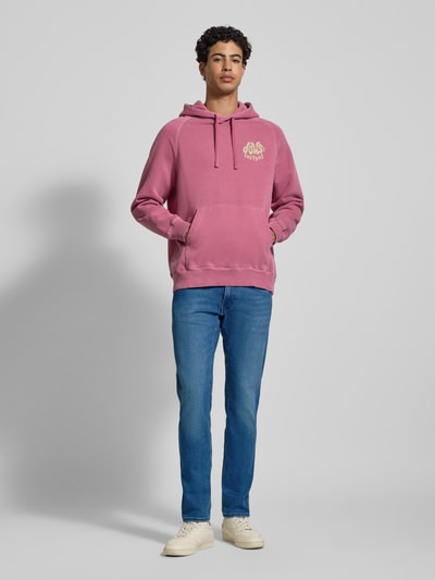 Männermodel trägt Slim Fit Jeans mit Eingrifftaschen Modell 'ANBASS' von Replay im Used-Look aus Baumwoll-Mix mit Stretch-Anteil, Ganzkörperansicht von vorne.