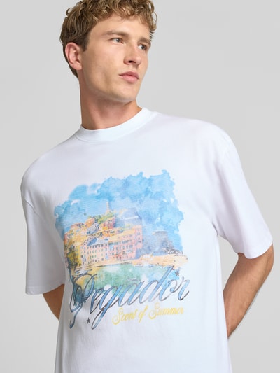 Männermodel trägt Oversized T-Shirt mit Motiv-Print Modell 'Sanji' von PEGADOR in Weiß, Baumwolle, Rundhalsausschnitt, Nahaufnahme Oberkörper.