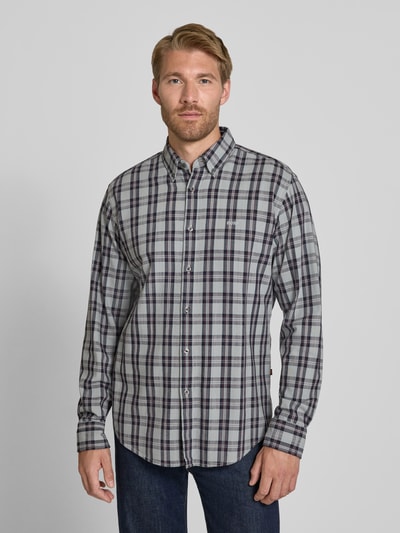 Męskamodel nosi koszulę casualową Regular Fit Freizeithemd aus Baumwoll-Viskose-Mix model 'Ricoplus_M' von BOSS Orange, kratka, odcienie szarości, granatu i bordowego, długie rękawy, gładka tekstura, Ganzkörperansicht von vorne.