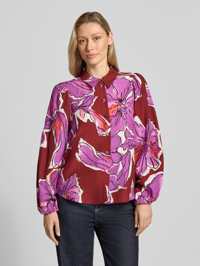 Frauenmodel trägt Bluse aus Viskose-Mix mit Ballonärmeln und Knopfleiste von Rich & Royal in Rot mit lila Blumendruck, gerader Schnitt, Hemdblusenkragen, elastische Ärmel, Ganzkörperansicht von vorne.