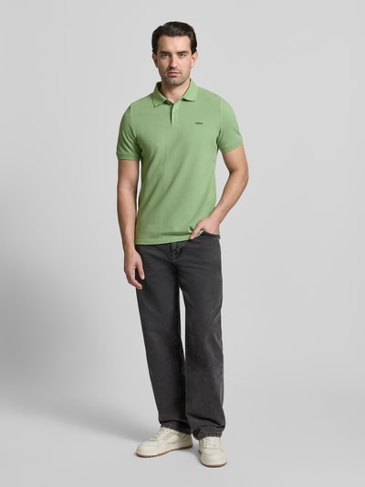 Mannenmodel draagt Regular Fit Poloshirt uit zuivere katoen van s.Oliver RED LABEL, effen groen, polokraag, korte mouw, labelstiksel, piquéstof. Volledige lichaamsvoorzijde.