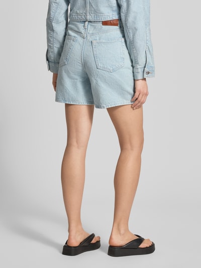 Frauenmodel trägt Jeansshorts im 5-Pocket-Design Modell '90S' von Calvin Klein Jeans in hellem Blau, Reine Baumwolle, Wide-Fit, Label-Detail, Ganzkörperansicht Rückansicht.