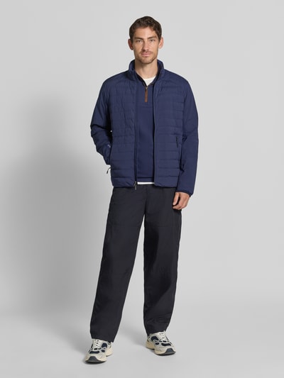 Mannenmodel draagt regular fit schipperstrui met korte ritssluiting van Polo Ralph Lauren in effen donkerblauw, ganzicht van voren.