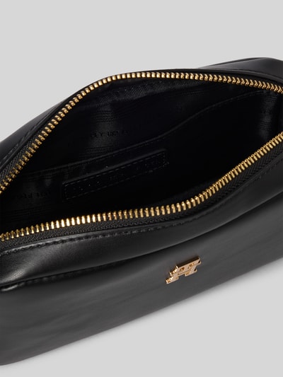 Produktfoto, Umhängetasche in Leder-Optik von Tommy Hilfiger in Schwarz mit goldfarbenem Logo, Reißverschluss und Schulterriemen, Hauptfach sichtbar