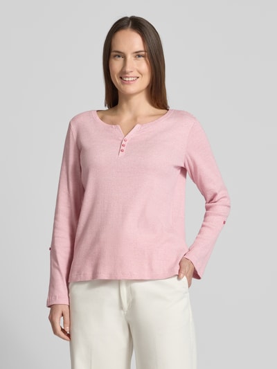 Modelka nosi Regular Fit Langarmshirt aus Baumwoll-Mix von Tom Tailor w kolorze różowym, dwutonowy, dzianina prążkowana, dekolt w serek, długi rękaw, label stitching, widok całej sylwetki z przodu.