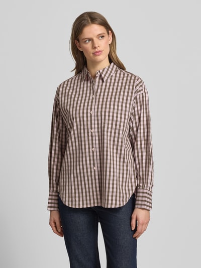 Modelka kobieca ma na sobie Relaxed Fit Hemdbluse Modell 'JAMIE' od JJXX z czystej bawełny w brązowo-białą kratę, kołnierzyk koszulowy, zapięcie na guziki, długość tyłu 77 cm, długość rękawa 55 cm, widok całościowy z przodu.
