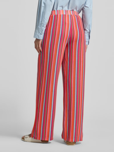Frauenmodel trägt Hose im Allover-Look Modell 'LIBELLA' von ICHI in Rot mit bunten Streifen, Material-Mix mit Stretch, Ganzkörperansicht Rückansicht