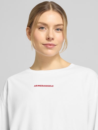 Frauenmodel trägt Oversized Langarmshirt aus reiner Baumwolle Modell 'FIETAA SMILE' von Armedangels in Optik: Unifarben mit Logo-Stitching, Materialverarbeitung: Feinripp, Vorderansicht Nahaufnahme Oberkörper.