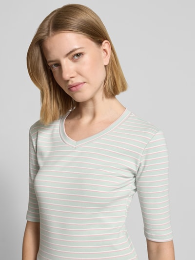 Frauenmodel trägt Longsleeve mit 3/4-Arm und V-Ausschnitt von Christian Berg Woman, gestreifter Baumwoll-Mix mit Stretch-Anteil, Nahaufnahme Oberkörper.
