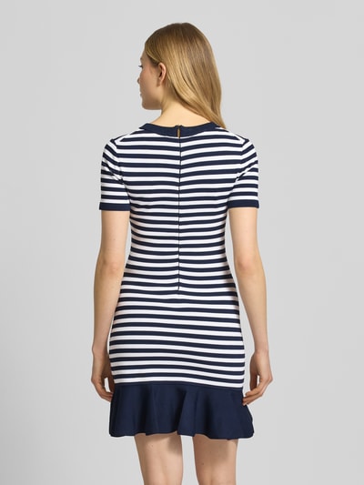 Frauenmodel trägt T-Shirt-Kleid aus Viskose-Mix mit Rundhalsausschnitt von MICHAEL Michael Kors, marine-weiß gestreift, körpernah, Minilänge, Rückansicht, Ganzkörperansicht.