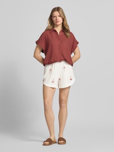 Frauenmodel trägt weiße Relaxed Fit Shorts aus reiner Baumwolle Modell 'KIANA' von Pieces mit Stickerei, unifarben, Ganzkörperansicht von vorne.