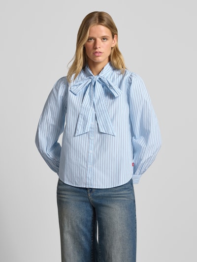 Frauenmodel trägt Regular Fit Langarmbluse aus reiner Baumwolle von Levi's® 300, hellblau mit feinen Streifen, lockere Passform, Ganzkörperansicht von vorne.