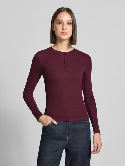 Frauenmodel trägt Slim Fit Langarmshirt aus Baumwoll-Mix von Jake*s Casual in Dunkelrot vor grauem Hintergrund, Ganzkörperansicht von vorne.