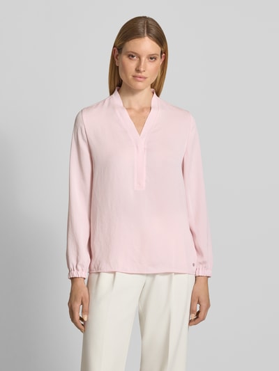 Modelka prezentuje Regular Fit Bluse mit V-Ausschnitt von Marc Cain, jasnoróżowa bluzka, krój regular fit, dekolt w serek, detal z logo, długość tyłu w rozmiarze 36: 65 cm, długość rękawów w rozmiarze 36: 59 cm, widok całej sylwetki z przodu