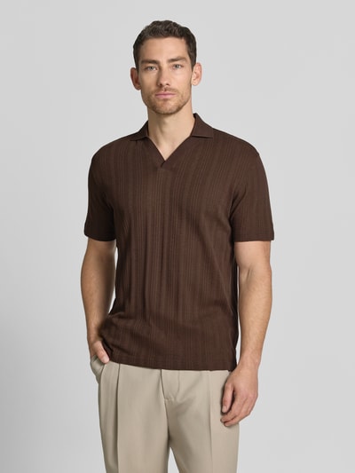 Männermodel trägt Regular Fit Poloshirt aus Baumwoll-Mix Modell 'TRAVIS' von SELECTED HOMME in Braun mit Struktur, Nahaufnahme Oberkörper.