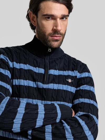 Männermodel trägt Slim Fit Troyer in Strick-Optik van Gant, blauw met zwarte strepen, ritskraag, logo, katoen, slim fit, Nahaufnahme Oberkörper.