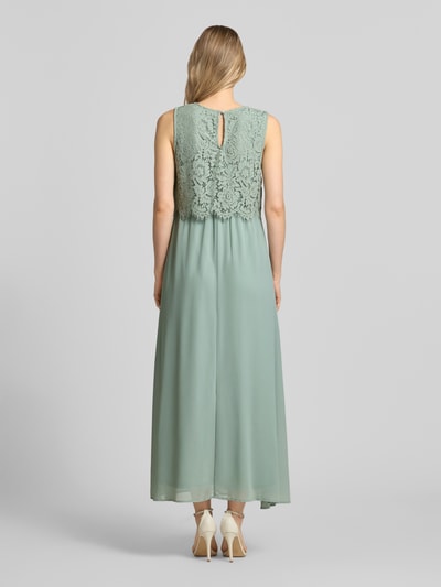 Frauenmodel trägt Maxikleid mit rückseitigem Schlüsselloch-Ausschnitt von Vila aus Baumwoll-Mix, Gerader-Schnitt, Spitze, Ganzkörperansicht Rückansicht.