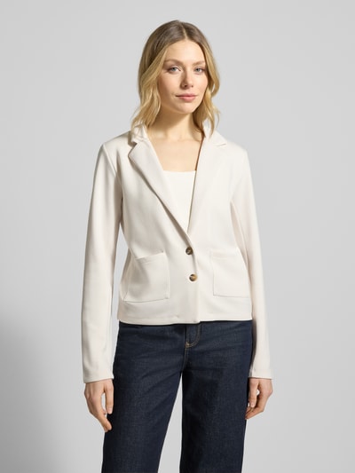 Modelka nosi Sweatblazer mit Taschen und Revers von Christian Berg Woman, mieszanka materiałów z modalu, krój regular fit, kołnierz z połami, zapięcie na guzik, jasny kolor, prosta forma, gładka faktura, widok całej sylwetki z przodu.
