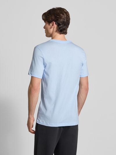 Männermodel trägt T-Shirt mit Label-Stitching von Nike in Hellblau, Reine Baumwolle, Regular-Fit, Rundhalsausschnitt, Rückenlänge 73 cm, Ganzkörperansicht Rückansicht.