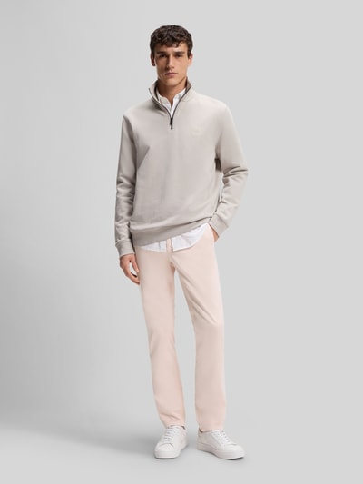 Männermodel trägt Slim Fit Chino aus Baumwoll-Mix von BOSS Orange, Optik: Unifarben, Materialverarbeitung: Twill, Ganzkörperansicht von vorne.