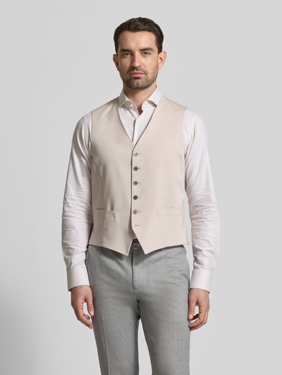 Mannenmodel draagt Regular Fit Weste uit viscose-mix met V-hals van JOOP! Collection, beige tint, knoopsluiting, steekzakken, voorkant geheel zichtbaar, regular fit, katoenmix, ruglengte 59 cm maat 50. Ganzkörperansicht von vorne.