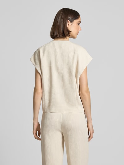 Frauenmodel trägt Bluse aus Viskose-Mix mit Eingrifftaschen Modell 'Wenali' von OPUS PANTS, cremefarben, strukturierte Oberfläche, Ganzkörperansicht Rückansicht, Loose Fit, Kappärmel, Rundhalsausschnitt, Rückenlänge bei Größe 36: 49 cm.