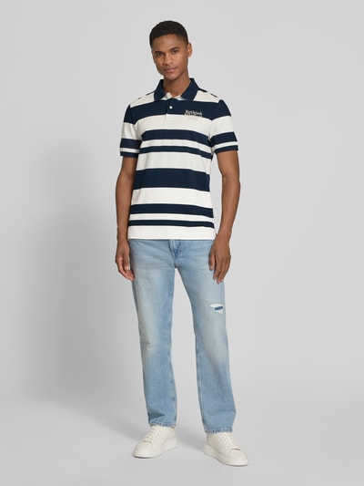 Männermodel trägt Regular Fit Poloshirt aus reiner Baumwolle von s.Oliver RED LABEL, gestreift in Two Tone Optik, Ganzkörperansicht von vorne.