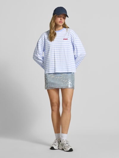 Frauenmodel trägt Relaxed Fit Sweatshirt mit Motiv-Stitching von REVIEW, weiß-blau gestreift, reine Baumwolle, Ganzkörperansicht von vorne.