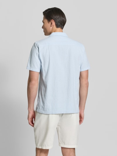 Męski model nosi Relaxed Fit Freizeithemd mit Leinen-Anteil od Lindbergh, jasnoniebieski, krótki rękaw, wzór strukturalny, bawełna z lnem, długość pleców w rozmiarze M: 73 cm, szerokość ramion w rozmiarze M: 46 cm, długość rękawa w rozmiarze M: 26 cm, widok całej sylwetki z tyłu.