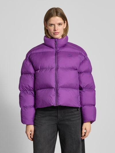 Vrouwenmodel draagt Steppjacke mit Label-Print - PUMA X P&C*, recht model, unicolour design, ritssluiting, steekzakken, vooraanzicht bovenlichaam.