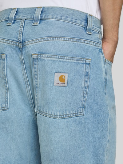 Männermodel trägt Relaxed Fit Jeans aus reiner Baumwolle Modell 'Brandon' von Carhartt Work In Progress, hellblauer Denim, Detailaufnahme Rückansicht, 5-Pocket-Design, sichtbares Markenzeichen, Teil des Kontexts: Herren Jeans, Knopf- und Reißverschluss, Gürtelschlaufen, Bundweite 46 cm, Innenbeinlänge 73 cm.